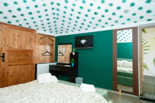a bedroom with a bed and a green wall at Maison à Skhirat Jacuzzi, jardin & proche plage in Skhirat