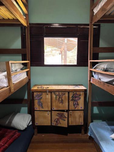 een kamer met twee stapelbedden, een ladekast en een raam bij Quarto Golfinhos - Masculino in Pipa