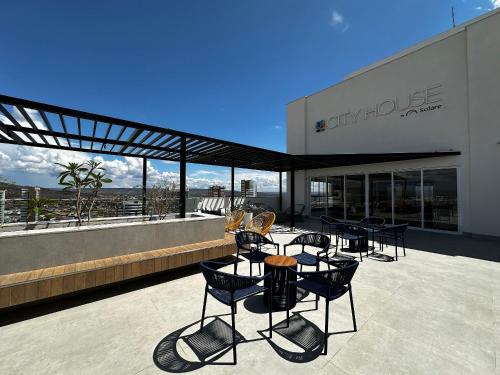 a patio with chairs and tables in front of a building at Apartamentos Exclusivos no Edifício City House in Barreiras