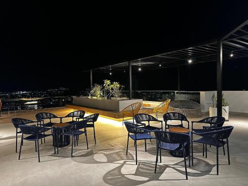 a group of chairs and tables on a rooftop at night at Apartamentos Exclusivos no Edifício City House in Barreiras