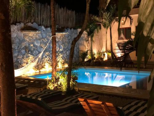 a swimming pool in a resort with palm trees at Aldea San Lam - Oasis Of Tulum in Tulum