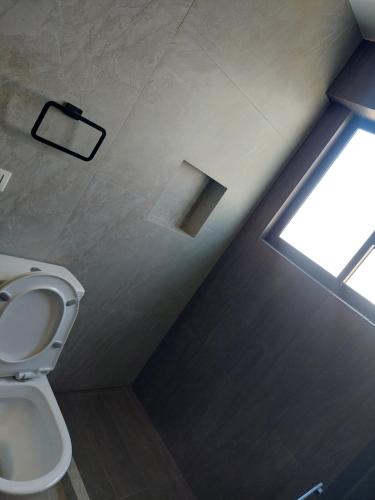 a bathroom with a toilet and a window at Prados del Oeste in Cochabamba