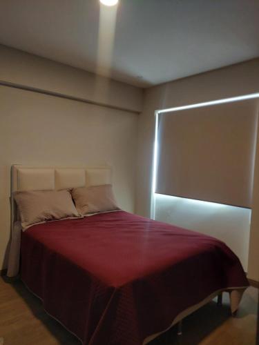 a bedroom with a bed with a red blanket at Prados del Oeste in Cochabamba