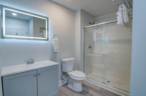 a white bathroom with a shower and a toilet at Ocean Escape Boardwalk Oceanfront in Myrtle Beach