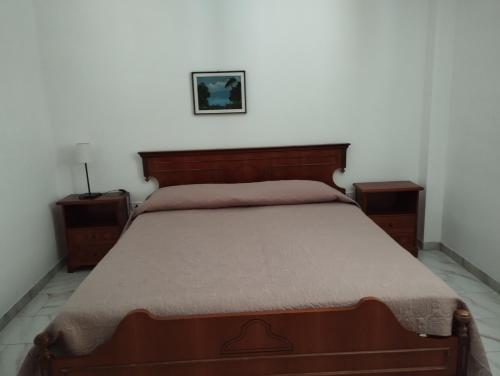 a bedroom with a bed with a wooden head board at Canto delle Rane in Vieste