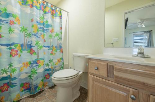 a bathroom with a toilet and a shower curtain at Funtiki in Whalebone