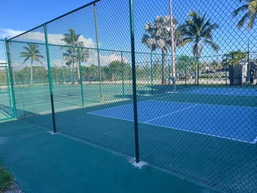 a fence on a tennis court with palm trees at Amazing Sunsets and dolphin sightings! in Fort Myers