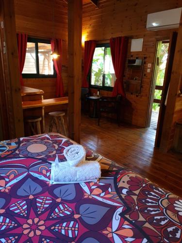 a bedroom with a bed in a wooden room at Itamar Cabins in Had Nes