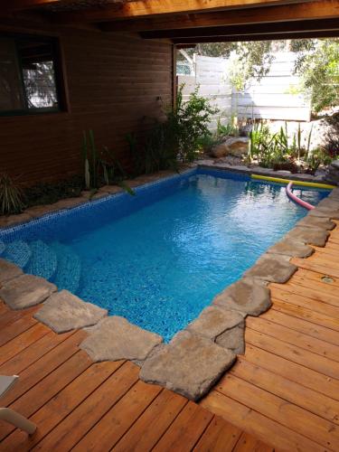 a swimming pool with a wooden floor and a wooden deck at Itamar Cabins in Had Nes