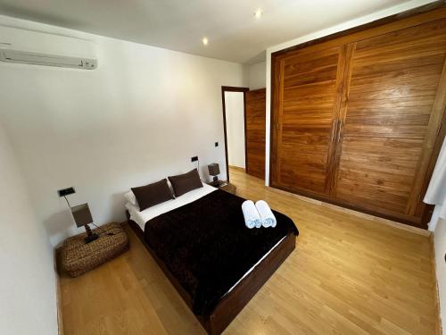 1 dormitorio con 1 cama y puerta de madera grande en Villa Ibiza Retreats, en Puig D’en Valls