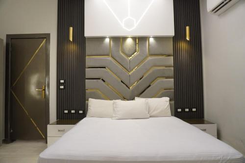a bedroom with a white bed with a gold wall at Midtown Studio near Tahrir in Cairo