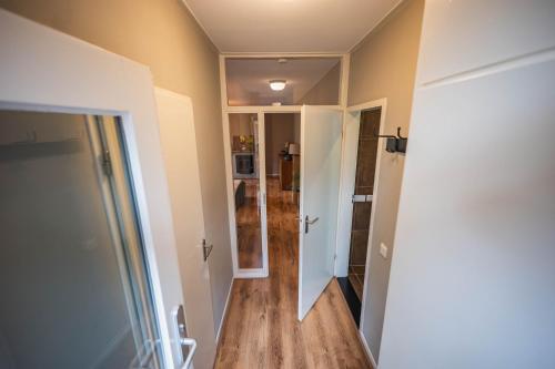 a hallway of a home with a door and wooden floors at Luxe boshuis in hartje Drenthe in Spier