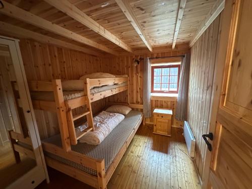 a room with two bunk beds in a log cabin at Bjorliheimen Fjellhotell-Hytte 11 & 12 in Bjorli