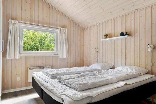 un letto in una stanza con una finestra di BV259-Blavand-Almosetoften-17 a Blåvand