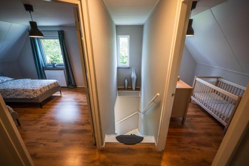 a hallway leading to a bedroom with a bed at Luxe boshuis in hartje Drenthe in Spier