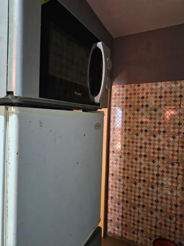 a microwave sitting on top of a refrigerator at Home RÉSIDENCE OUIDAH in Ouidah