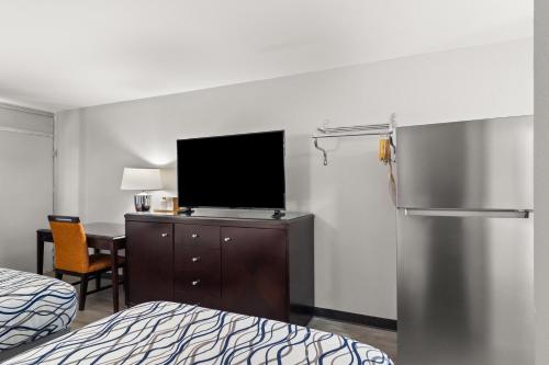 una camera d'albergo con TV e frigorifero di Suburban Studios a Orange Park