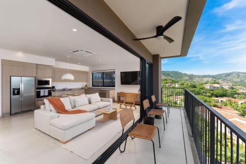 an open living room and kitchen with a balcony at Sol Pacífico at Naumi, Ocean Views & Beach Club in Sardinal