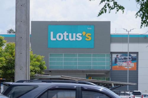 a sign for a store with a car parked in a parking lot at Parsons Place in Chiang Mai! in Chiang Mai