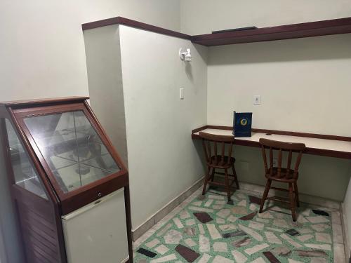 a small room with a desk and two chairs at Hotel Arsenal in São Gonçalo