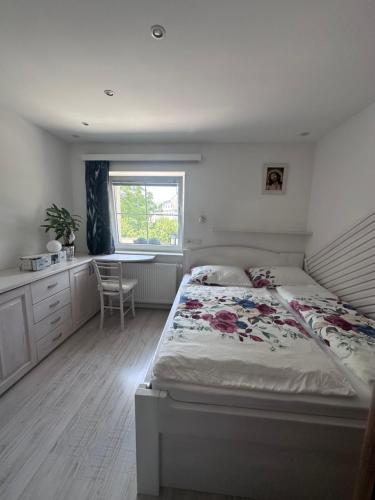 a bedroom with a bed and a desk and a window at Hiša Srečo in Begunje na Gorenjskem