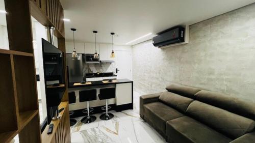 ein Wohnzimmer mit Couch und Küche in der Unterkunft studio guarulhos 1105 in Água Boa