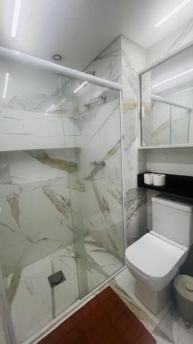 ein Badezimmer mit Toilette und Glasdusche in der Unterkunft studio guarulhos 1105 in Água Boa