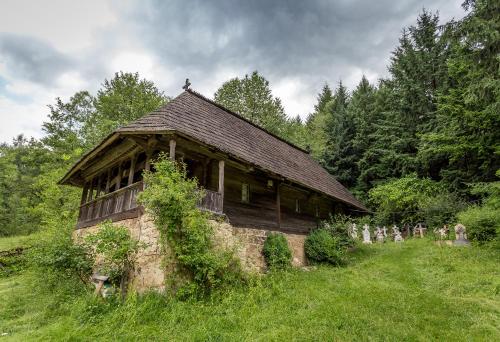 an old building in the middle of a field at Hanul Vatra in Horezu