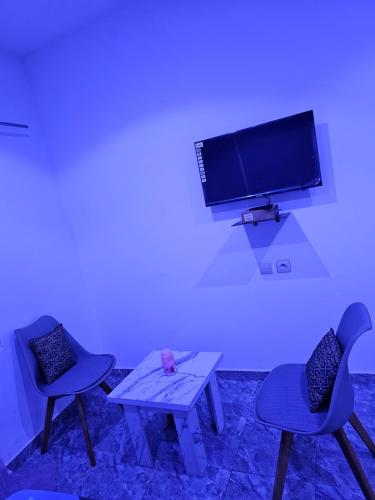 a room with two chairs and a tv on a wall at Home RÉSIDENCE OUIDAH in Ouidah