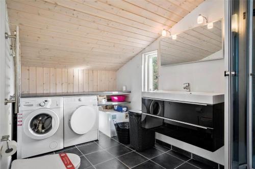 a bathroom with a washing machine and a sink at 0018-Romo-Trinnesvej-16 in Bolilmark