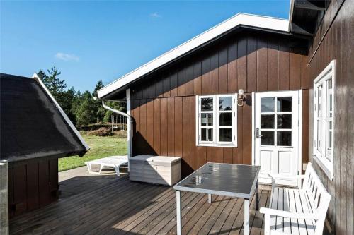 a wooden deck with a table and a house at 0018-Romo-Trinnesvej-16 in Bolilmark