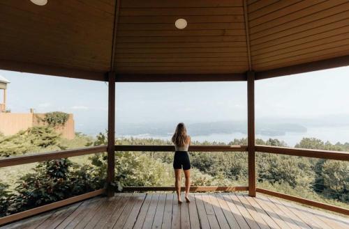 a woman standing on a wooden deck looking out at the view at critter corner at Grant Summit Cabins in Bryant