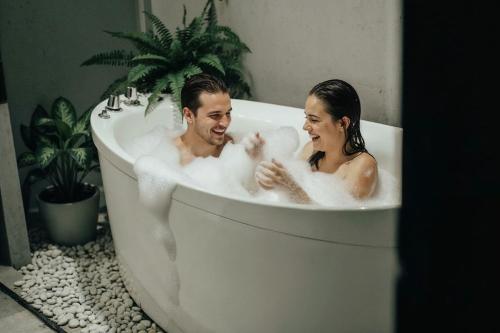 a man and woman sitting in a bath tub at Kue Hotel Maafushi in Maafushi