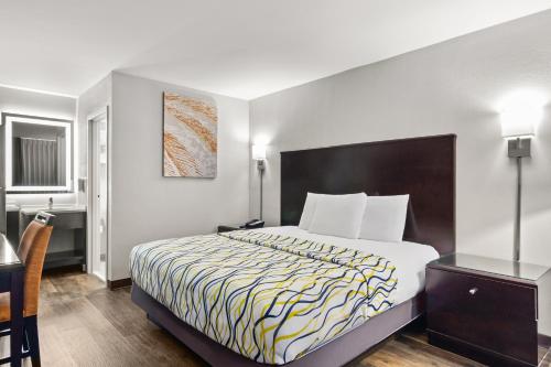 una camera d'albergo con un letto e una scrivania di Suburban Studios a Orange Park