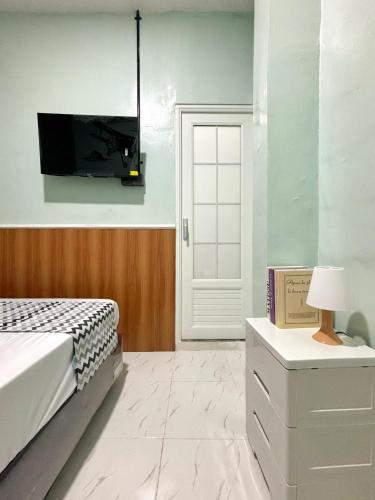 a bedroom with a bed and a tv on the wall at Semarang CoStay in Alastuwo