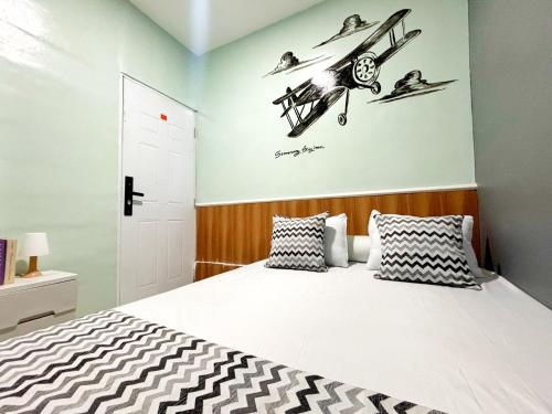 a bedroom with a bed with a plane on the wall at Semarang CoStay in Alastuwo