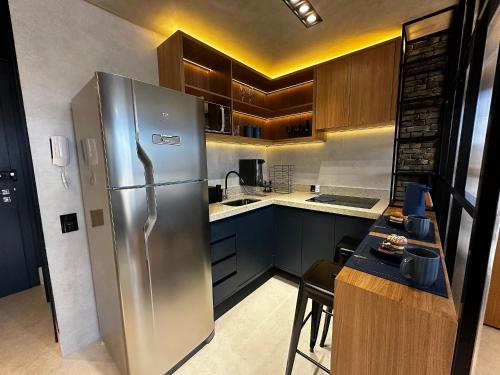 a kitchen with a large stainless steel refrigerator at Apartamentos Exclusivos no Edifício City House in Barreiras