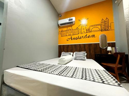 a bed in a room with a sign on the wall at Semarang CoStay in Alastuwo