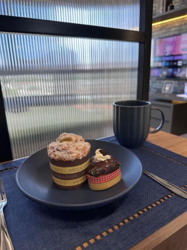 two cupcakes on a blue plate on a table at Apartamentos Exclusivos no Edifício City House in Barreiras