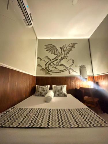 a bedroom with a bed with a dragon on the wall at Semarang CoStay in Alastuwo