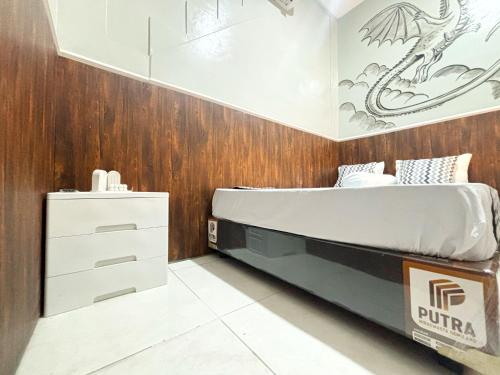 a bedroom with a bed and a wooden wall at Semarang CoStay in Alastuwo