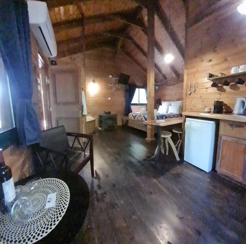 a kitchen and living room of a wooden cabin at Itamar Cabins in Had Nes