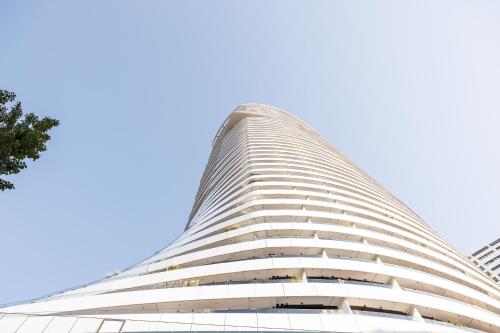 a tall building with a blue sky in the background at Skyline Suite - Danube-View Balcony & Pool in Vienna