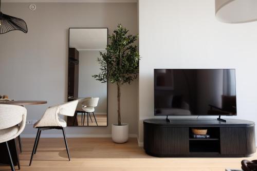 a living room with a tv and a table and chairs at Skyline Suite - Danube-View Balcony & Pool in Vienna
