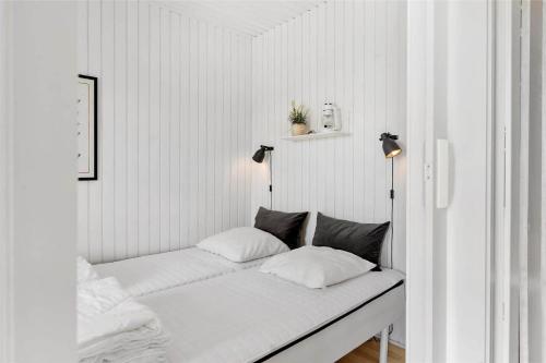 Habitación blanca con 1 cama con 2 almohadas en 0291-Romo-Vestergade-3-Ap-65, en Havneby