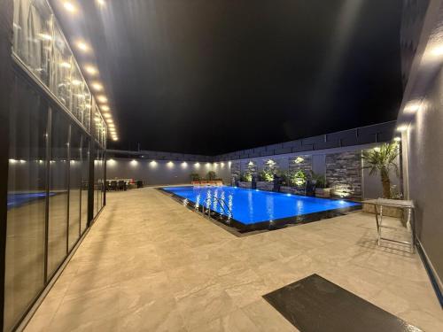 a large swimming pool in a building with a lit room at Taj Villa 2 - entire Villa in Deadsea front beach in Sowayma