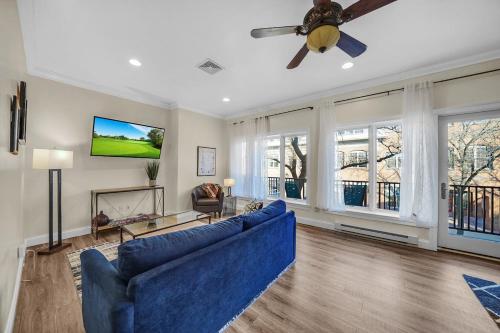 a living room with a blue couch and a ceiling fan at Loft Apt with Balcony in the Heart of Kennett Square in Kennett Square