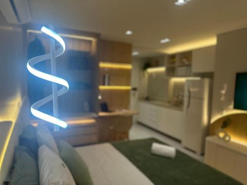 a room with a bed with a neon sign on it at Apartamentos Exclusivos no Edifício City House in Barreiras