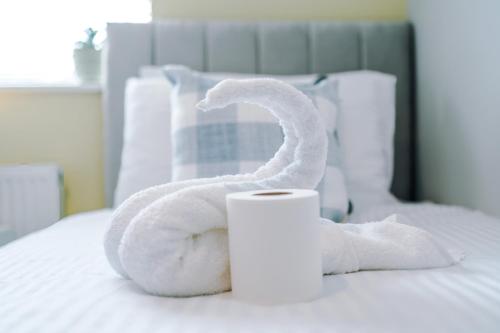a white towel snake sitting on a bed at 3BR House By Eason Stays Short Term Rental Wythenshawe Near Manchester Airport with Free Parking in Wythenshawe