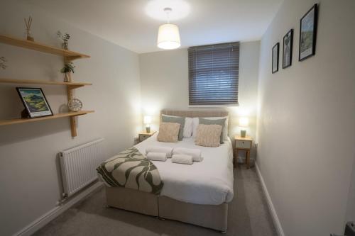a bedroom with a bed with white sheets and pillows at Relaxing Town Centre House - Perfect for Exploring in Shrewsbury